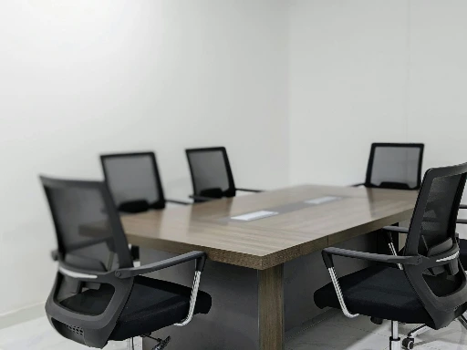 Modern office meeting room in Salalah, Oman with black chairs around a wooden conference table